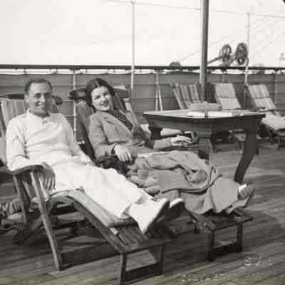 Coe_Natalie_040: Natalie Coe and Leonardo Vitetti sitting in chairs on deck of ship