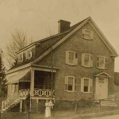 Coe_Natalie_054: Natalie Coe propped on fence in front of house; "Natalie Mai Coe c. 1912 with nurse Kate Williams in New Jersey"" written on back