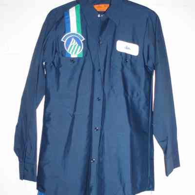 Dark blue shirt with vertical green, white and royal blue stripe on right chest with mountain logo patch on top. Left chest name patch "Jim". American flag patch on left shoulder. Includes matching navy pants with royal blue stripe.
late 1980's - 1990.