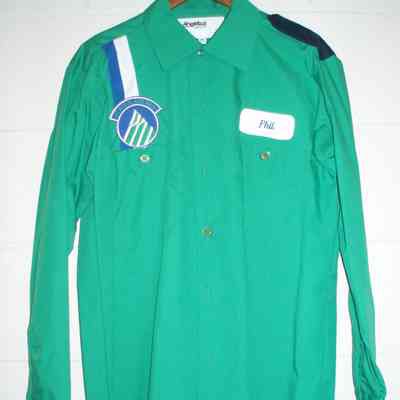Green mechanic shirt.  Name patch "Phil" on left chest, Alaska mountain logo with one blue and one white vertical stripe on right chest.