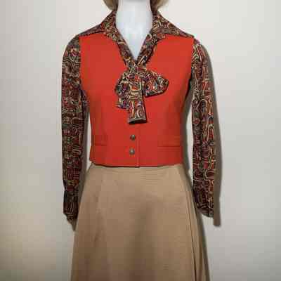 Beige skirt, orange vest, totem pole colored shirt/scarf. You could take the jacket off during the flight. Allowed to wear airline pin, AFA pin, name pin.