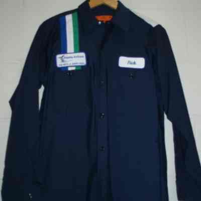Dark blue shirt with vertical blue, white and green stripes on right shoulder with Alaska Airlines "fly with a happy face" patch above right chest pocket, and name patch "Rick" above left chest pocket. Includes matching pants.
Late 1980's - 1990