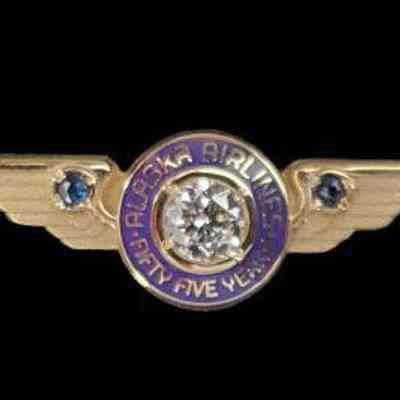 Alaska Airlines 55-year Service Pin - Gold Wings with one-third-carat diamond in the center, circled with "Alaska Airlines Fifty Five Years" and 2 sapphires on the wings