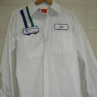 White mechanic shirt.  "Bob" name patch on left chest.  One navy, one green, vertical stripe with Alaska Airlines "fly with a happy face" patch on right chest.