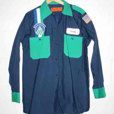 Dark blue shirt with green pockets and green cuffs. Vertical green, white & royal blue stripe on right chest with mountain logo patch on top. Left chest name patch "Randy". American flag patch on left shoulder. Includes matching navy pants with green stripe.
Late 1980's - 1990.