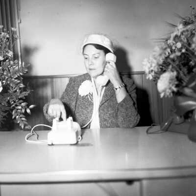 October 1956 Conversion of telephone system from operator directed to dial telephones in Cheney.Mrs. Slawson dialing the phone