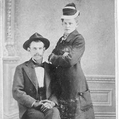 Photo of unidentified sitting man and woman with crossed arms