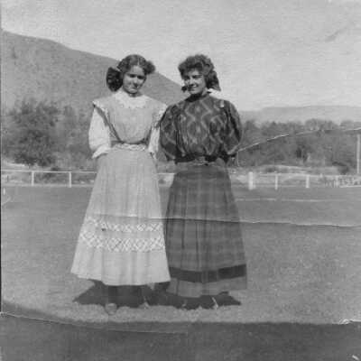 early 1900s photo of two young women on a farm or rodeo ground