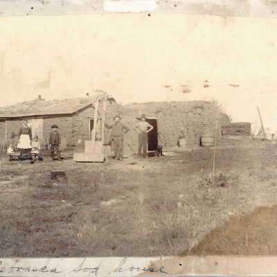 family standing outside a Nebraska sod house.
