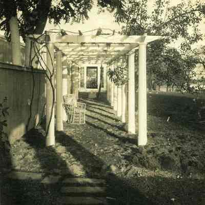 Looking towards covered walkway without vegetation at "The Hill" with chair