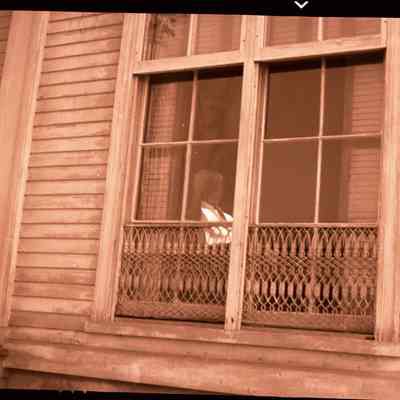 Alexander Palmer Loper at window inside Palmer House (Pine Point)