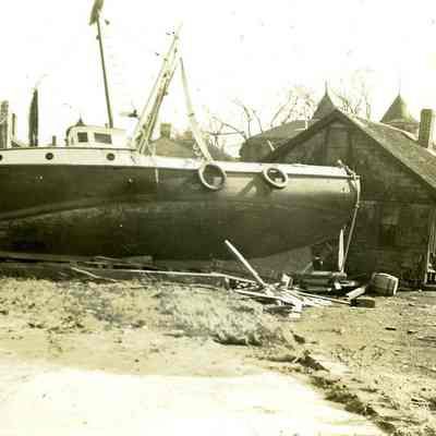 Fishing boats washed up against buildings