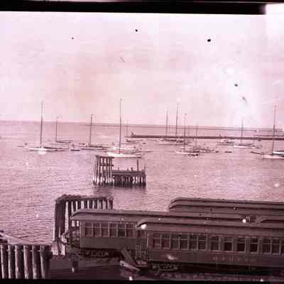 Sailboats in Stonington Harbor with train cars on dock