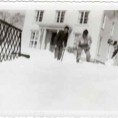 Three men shoveling snow on driveway of Palmer House