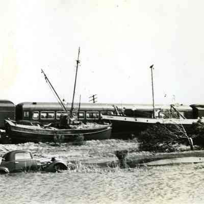 Cars and boats against derailed train