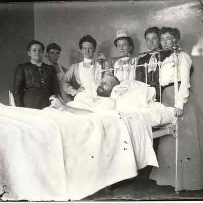 Man in sick bed with caregivers
