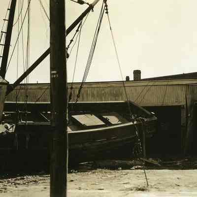 Fishing boat washed up against building