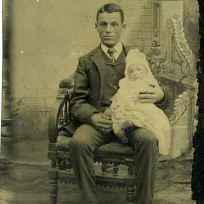 Unknown man seated with baby on lap