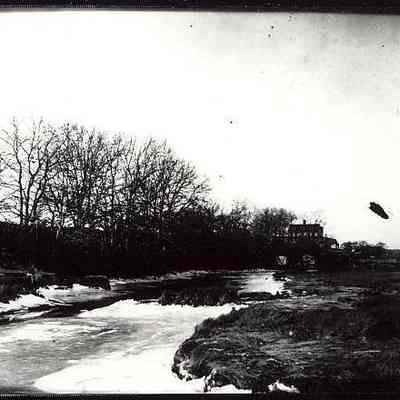 Unidentified river/flooded stream with house in background