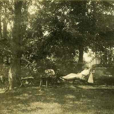 Woman in lounge chair under tree at "The Hill"