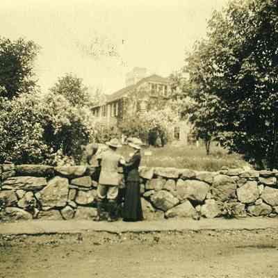 Man and woman at stone wall looking at "The Hill"