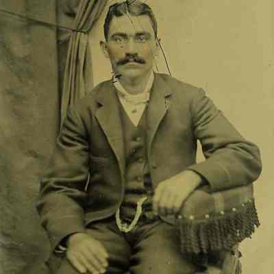 Unknown man seated on plaid chair