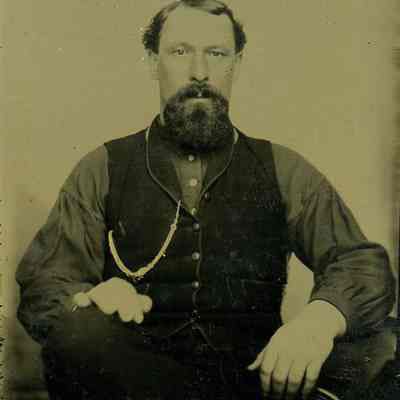 Unknown bearded man seated with ornate chain and vest