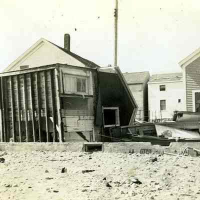 Damaged houses with one on its side