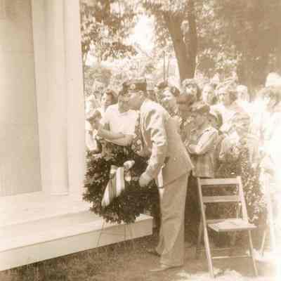 Burrows Perry placing flowers on Stonington Honor Roll