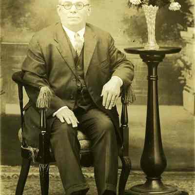 Unknown older man, seated with vase of flowers