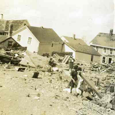 People looking at destroyed and damaged houses
