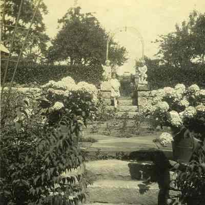 Stone wall, steps and angels with girl in garden at "The Hill"