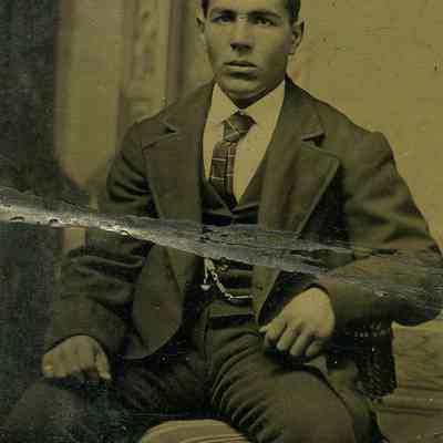 Unknown young man seated, pocket watch on chain and long tie