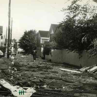 Peoplel walking down debris filled street