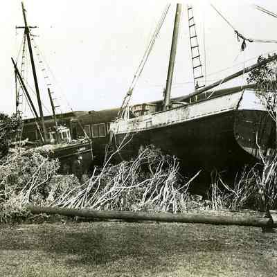 Fishing boats washed up against derailed train