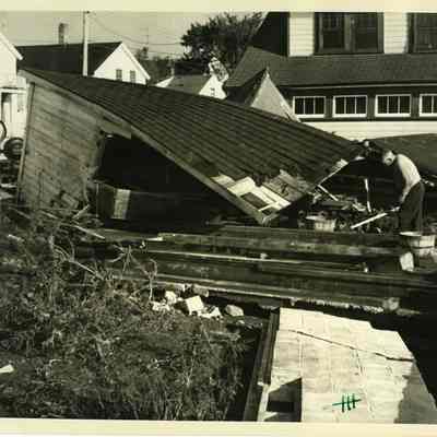 Man working on debris of demolished house
