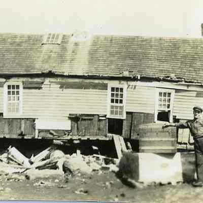 Man in front of damaged/destroyed house
