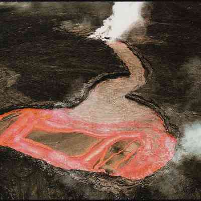 Author's Personal Collection: A lava lake at the Kupaianaha shield on Kilauea's east rift zone. Lava upwells from below and drains into an underground lava tube. Lava in this tube system eventually reached the ocean, over 6 miles from the vent. J. D. Griggs 1987.