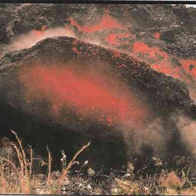 Author's Personal Collection: An accretionary lava ball tumbles down the steep front of an 'a'a flow. These balls are formed on a moving flow by the accumulation of viscous lava around an already solidified core. J. D. Griggs 1983.