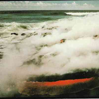 Author's Personal Collection: Lava meets the sea, gradually adding new land to the island. The interaction between sea water and hot, molten lava produces a steam cloud which contains hydrochloric acid and fine particles of volcanic glass. J.D. Griggs 1990.
