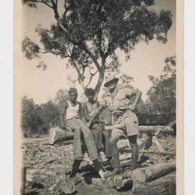 Unidentified Australian soldier standing alongside two (2) seated First Nations men