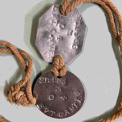 2023.1.6: Detail of two (2) metal Identity tags on cord.They show service number, religion, blood type and name.