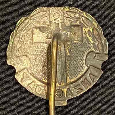 This image depicts the reverse of a vintage, commemorative Anzac Day pin. It shows the embossing used to create the details on the front of the pin.
