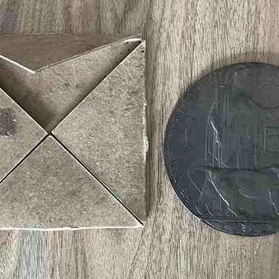 2023.27.1-2: Memorial Plaque and original cardboard envelope.
