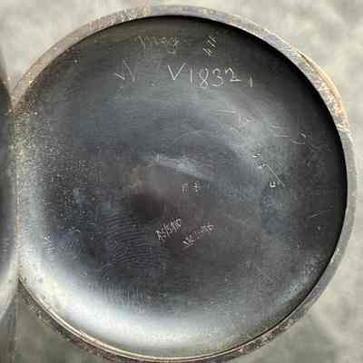 2023.24.1: Interior of back clasp showing owner's name and other markings.