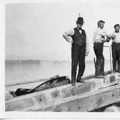 Four men on top of timbers