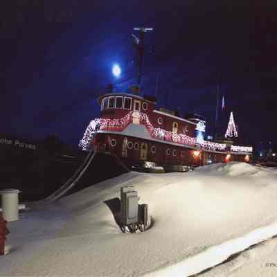 Tug John Purves docked in winter with Christmas lights