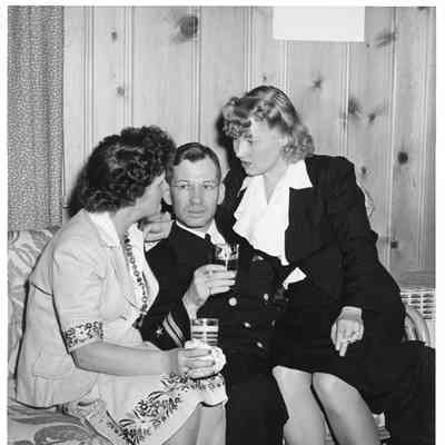 Unidentified military man and two women drinking