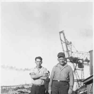 Two men on dock next to boat