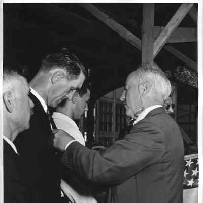 Merit badges being pinned on three L.D. Smith employees
